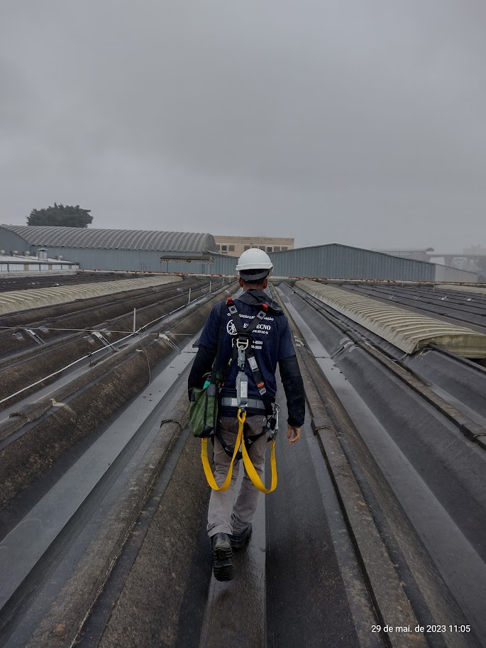 Técnico trabalhando com segurança em sistema de climatização industrial
